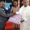 Prof. Isah Mshelgaru, Leader of a Muslim group who celebrate Christmas with Christians at EYN Church, Samaru Zaria, presenting gift to Rev. Tijjani Chindo, during the Christmas service at Zaria on Sunday.