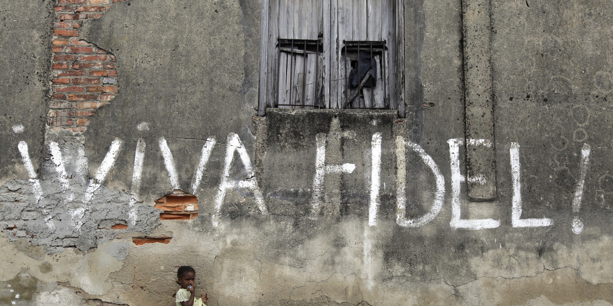 A girl stands next to graffiti that reads "Viva Fidel" (Long live Fidel), in Cuba's western province of Pinar del Rio February 23, 2010.