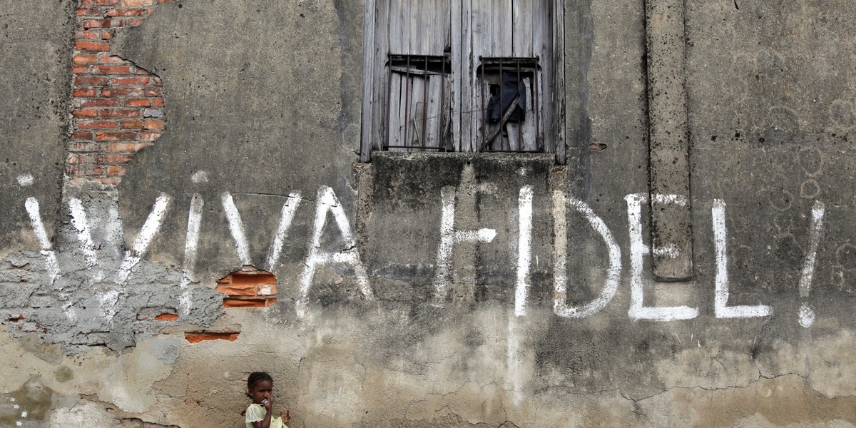 A girl stands next to graffiti that reads "Viva Fidel" (Long live Fidel), in Cuba's western province of Pinar del Rio February 23, 2010.