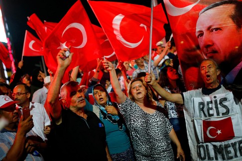 People shout slogans and wave Turkish national flags as they have gathered in solidarity night after