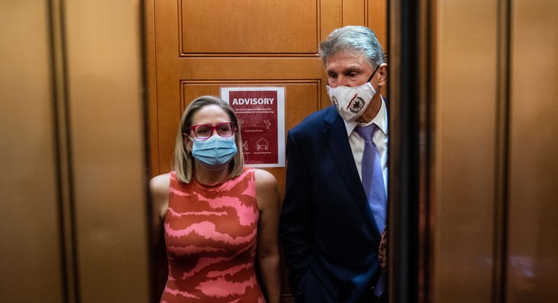 Democratic senators Kyrsten Sinema and Joe Manchin talk in a Senate elevator.