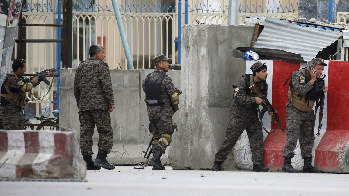 Afghan security forces take position at the site of a suicide car bomb attack in Kabul