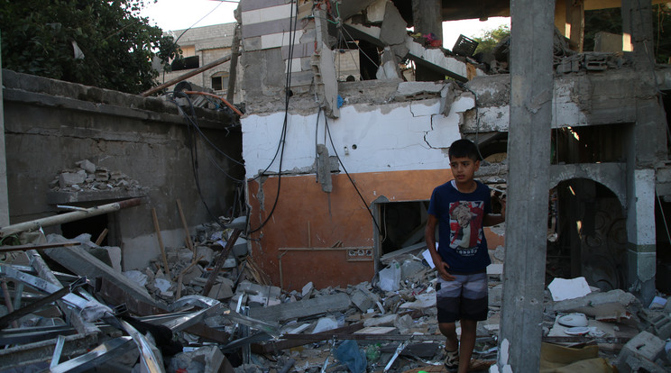 Helyi polgárok áldozatok után kutatnak olyan épületekben, amelyek az izraeli légitámadások során romboltak le a Gázai övezet déli részén / Fotó: Getty Images