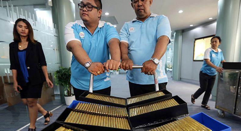 Employees push a trolley laden with crates of one kilogram gold bars at the YLG Bullion International Co. headquarters in Bangkok, Thailand.