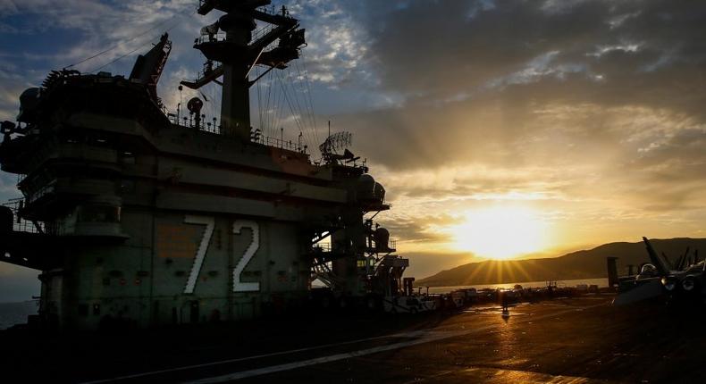 The sun sets as the Nimitz-class aircraft carrier USS Abraham Lincoln (CVN 72) is anchored off the coast of Palma de Mallorca, Spain.