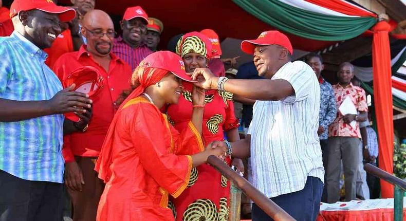 President Uhuru Kenyatta receives defectors during a public rally at Voi Stadium. Looking on is Dr Naomi Shaban.