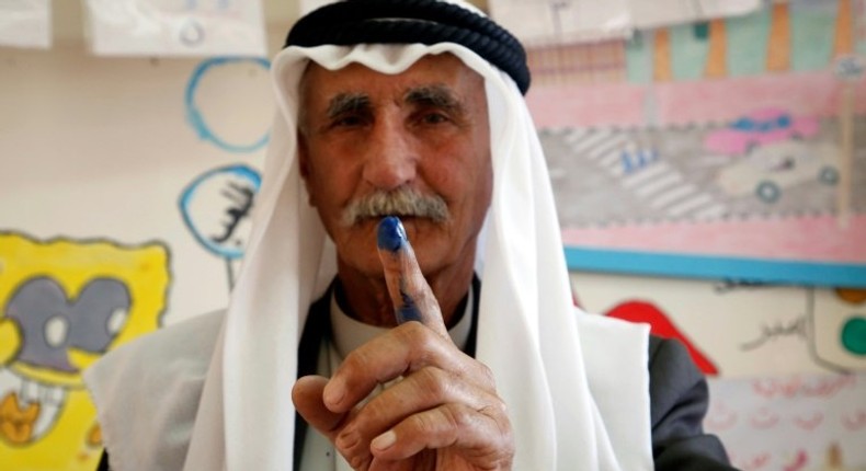 A Palestinian man shows his ink-stained finger after casting his ballot during municipal elections in the village of Yatta in the West Bank on May 13, 2017