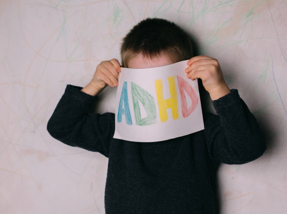 Dziecko z trzyma kartkę z napisem ADHD.