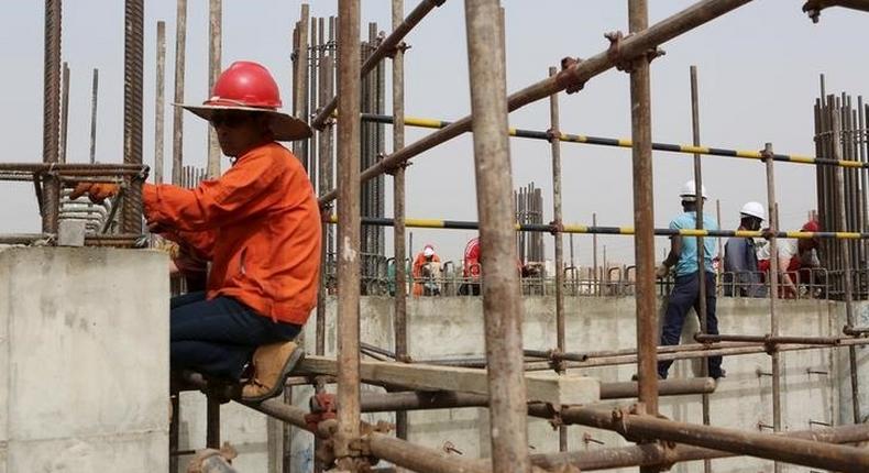 Chinese and Nigerien construction workers work on the site of an Islamic university in Niamey, Niger, February 22, 2016. 