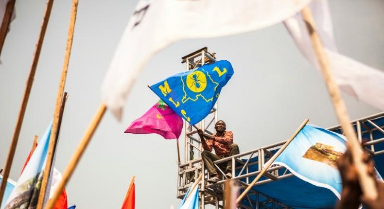 A demonstrator waves a party's flag of the Movement for the Liberation of the Congo (MLC), during a rally in support of Congolese President Joseph Kabila in Kinshasa, on July 29, 2016 