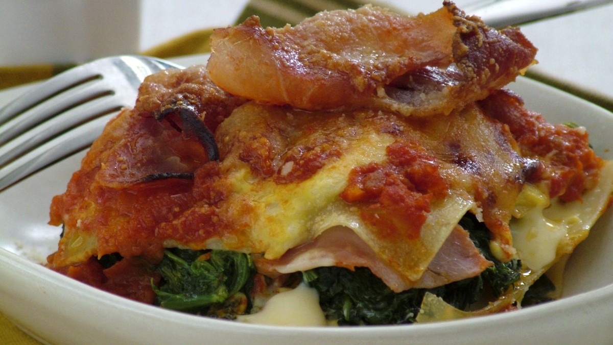 Portion of lasagne with parma ham, spinach and cheese