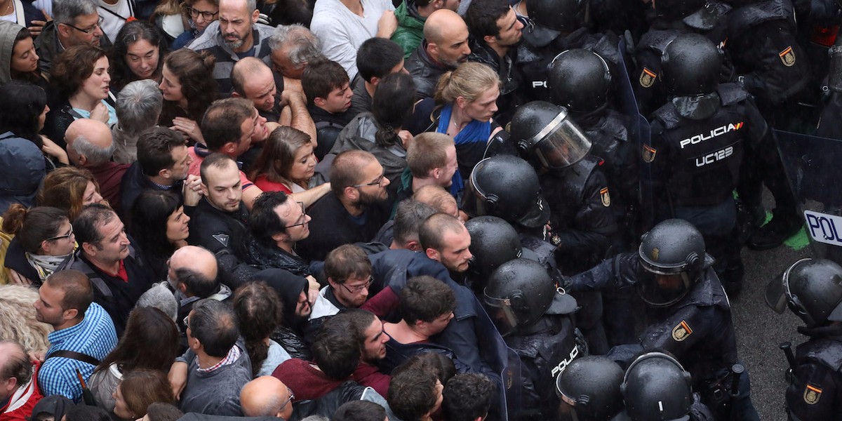 Riot police face off with demonstrators outside a polling station for the banned independence referendum in Barcelona, Spain, October 1, 2017.