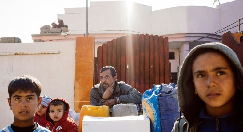 An Iraqi family wait with their belongings to return home on the western edge of Al-Intisar neighbourhood in southeastern Mosul, northern Iraq on January 5, 2017