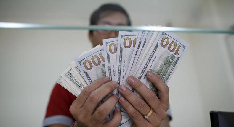 Bank staff shows U.S. hundred dollars bills at AYA Bank's money changer in Yangon July 17, 2015.   REUTERS/Soe Zeya Tun