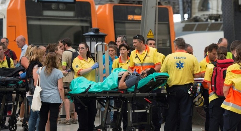 Emergency personnel help the injured after a commuter train hit the end of a platform at Barcelona's Francia station on July 28, 2017