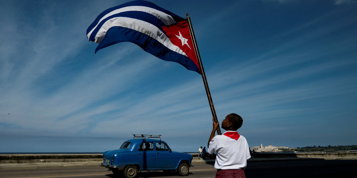 Kuba. Chłopiec macha flagą narodową, czekając na paradę upamiętniającą 65. rocznicę wjazdu Fidela Castro do Hawany 8 stycznia 2024 r.