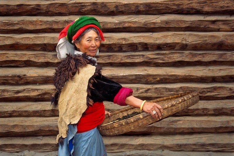 Mosuo - kobieta przed swoim domem [nad jeziorem Lugu, Yunnan, Chiny]