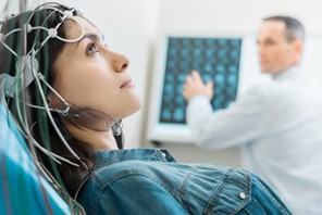 Charming young woman undergoing electroencephalography