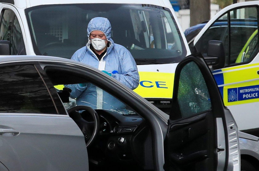 Police forensics officer works at the site where police fired shots after a vehicle rammed the parke