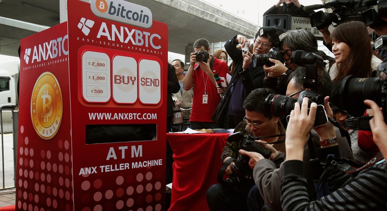 Photographers in front of a mock bitcoin ATM during the opening of Hong Kong's first bitcoin retail store in February 2014.