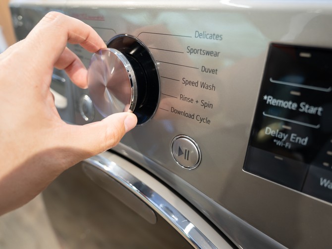 Adjusting,Washing,Machine,Setting.,Hand,Turning,The,Dial,Of,A