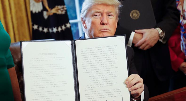 President Donald Trump signs an executive order in the White House.