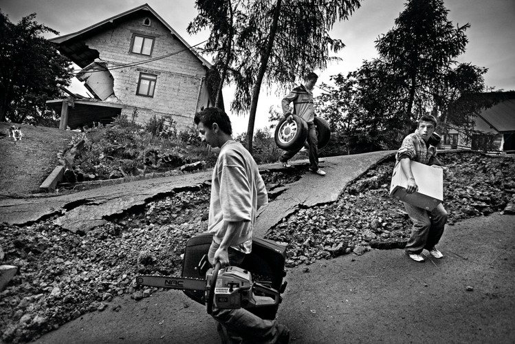 Zwycięzca w kategorii WYDARZENIA zdjęcia pojedyncze Mateusz Skwarczek, „Gazeta Wyborcza Kraków”. <br /><br />Kłodne koło Limanowej (Małopolska). Wskutek długotrwałych opadów namoknięte stoki wzgórz zaczęły się osuwać, pozbawiając dachu nad głową mieszkańców tej miejscowości. Zawaliło się kilkanaście budynków. Chłopcy wynoszą rzeczy z ruin swojego domu. 3 czerwca 2010