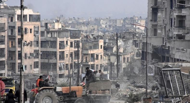 Residents use a tractor to collect belongings in the former rebel-held Zebdiye district in the northern Syrian city of Aleppo on December 23, 2016 after government forces retook control of the whole embattled city Syrian troops cemented their hold on Aleppo after retaking full control of the city, as residents anxious to return to their homes moved through its ruined streets.