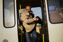 Kobieta jest wynoszona z autobusu po przybyciu do Zaporoża.