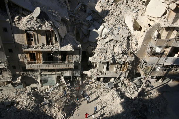 People dig in the rubble in an ongoing search for survivors at a site hit previously by an airstrike