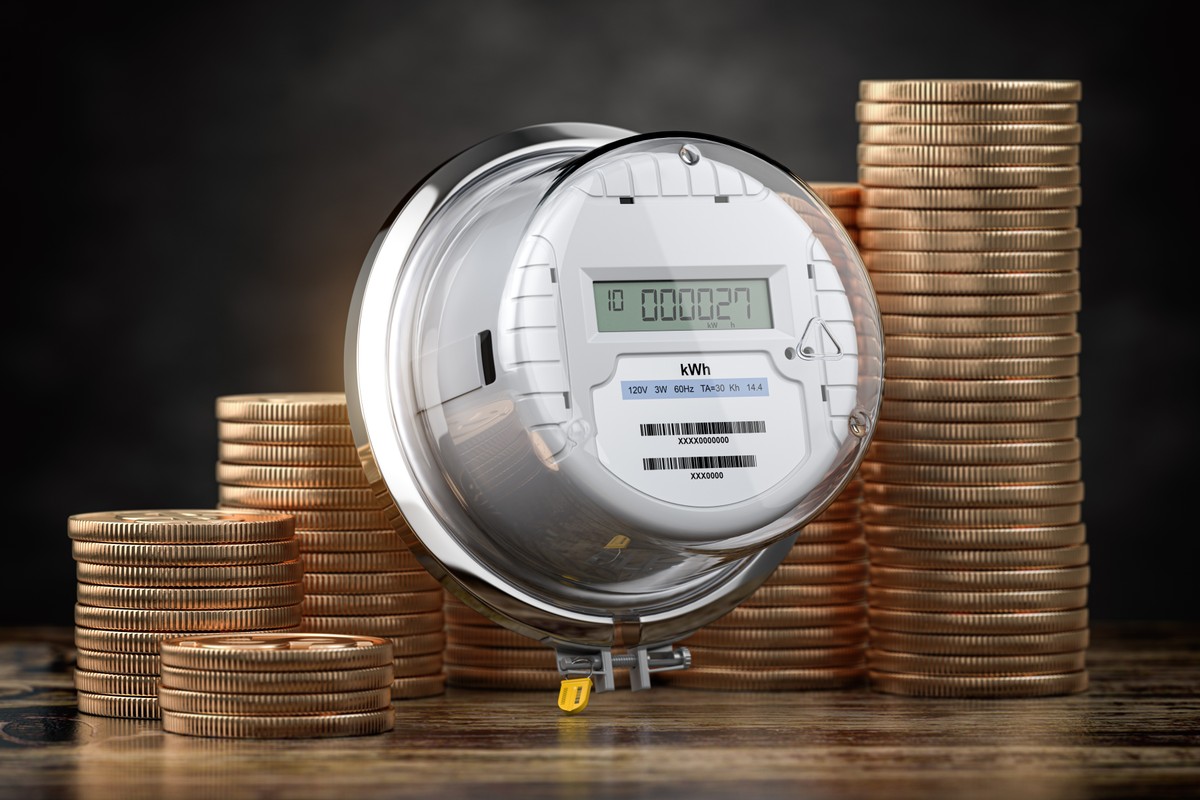 licznik energii elektrycznej, w tle monety