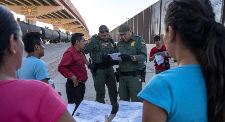 US Customs and Border Protection agents in May 2019 check documents in El Paso, Texas, from a small group of migrants who crossed from Mexico