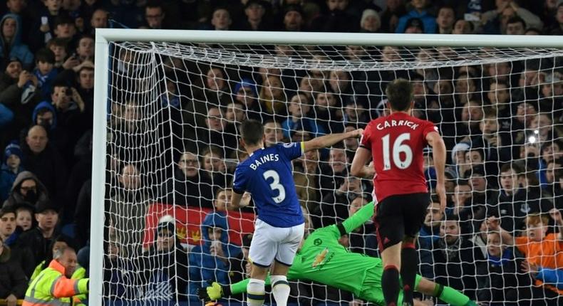 Everton's defender Leighton Baines (L) scores his penalty past the diving Manchester United's goalkeeper David de Gea during the English Premier League football match between Everton and Manchester United at Goodison Park on December 4, 2016