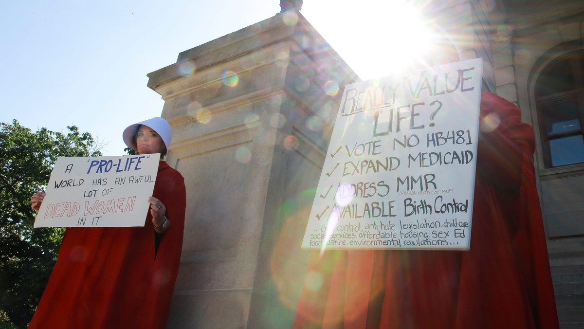 Protesters Houston and Martin hold signs against Georgia's anti-abortion heartbeat bill at Georgia State Capitol in Atlanta