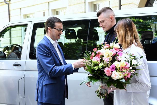 Mateusz Morawiecki wręcza kluczyki do dziewięcioosobowego Volkswagena Transportera rodzicom sześcioraczków Klaudii i Szymonowi Marcom 