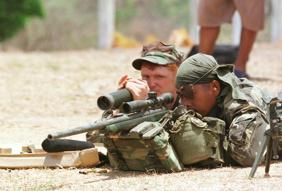 A US Marine instructs a Philippine soldier on how to use a sniper rifle in the Philippines.