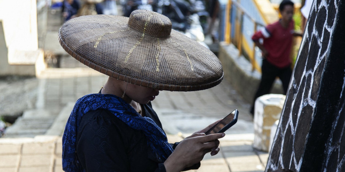 Internet dociera do coraz większej ilości miejsc na świecie. Na zdjęciu kobieta z plemienia Outer Baduy rozmawiająca za pomocą smartfona w wiosce Ciboleger w Indonezji