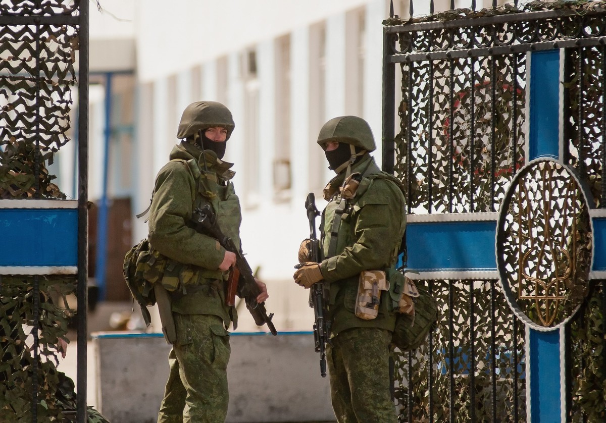 Sewastopol na Krymie. Uzbrojeni mężczyźni w mundurach przed ukraińską jednostką wojskową