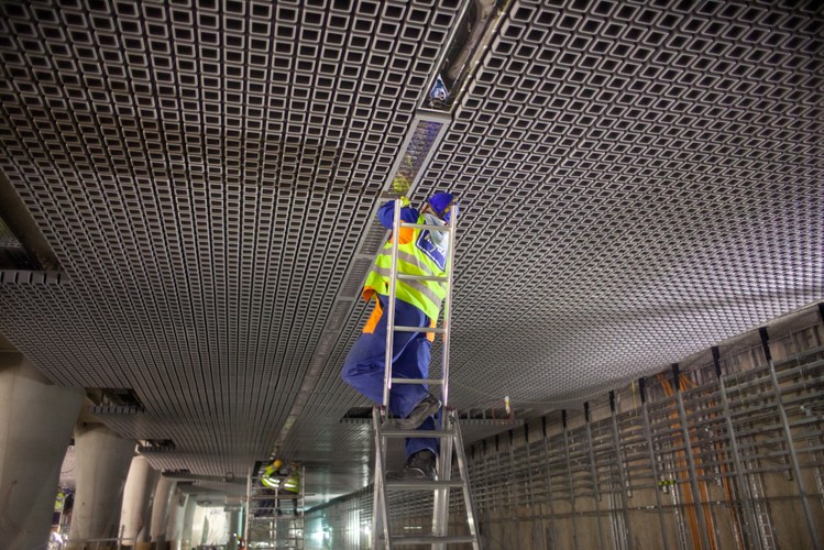Montowanie oświetlenia w suficie na stacji metra Rondo ONZ podczas budowy centralnego odcinka II linii kolei podziemnej w Warszawie, 25.04.2014