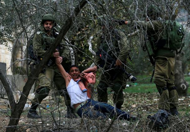 Israeli soldiers detain a Palestinian during clashes at a protest near the West Bank city of Nablus