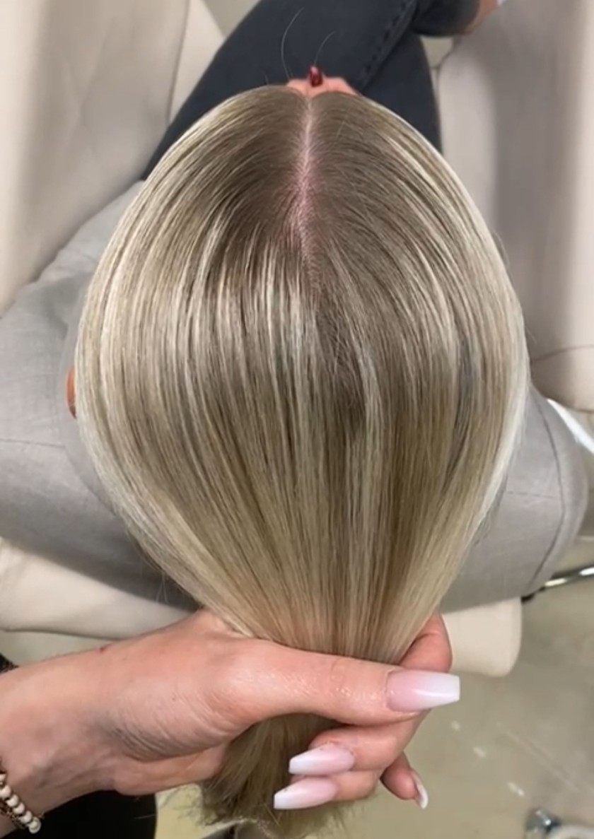 Pour réaliser cette coiffure tressée chic, il faut commencer par tracer une raie au milieu.