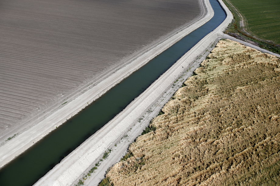 A canal runs through dried-up farm fields in Los Banos.
