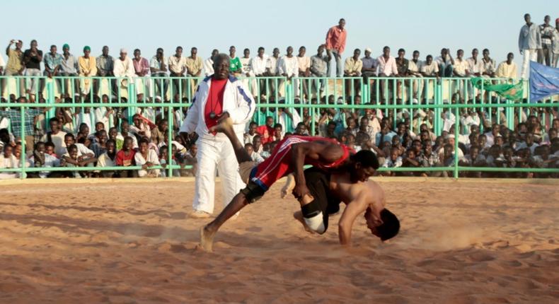 In this file photo from 2013, Japanese diplomat Yasuhiro Murotatsu, aka Muro (R) competes against Saleh Omar Bol Tia Kafi aka al-Mudiriya in a Nuba wrestling match in Khartoum