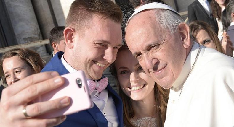 Pope Francis with a newly married couple 