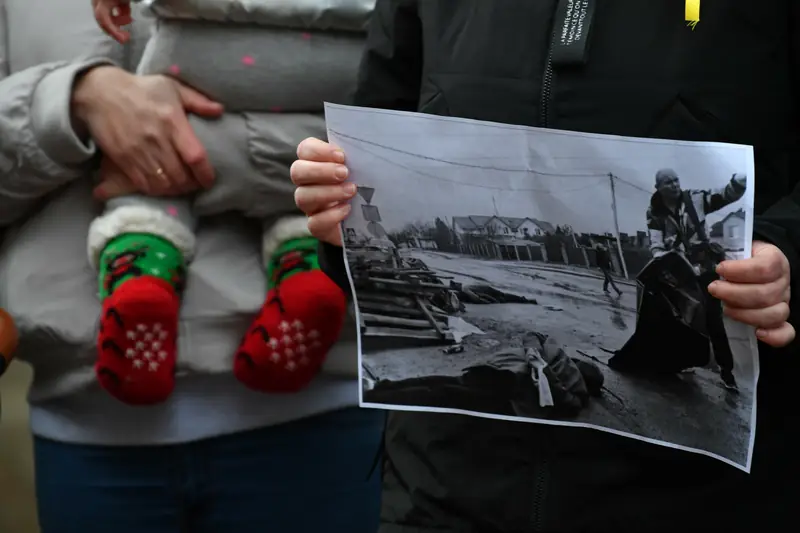 Demonstracja przeciwko Rosji na Ukrainę — protestująca trzyma zdjęcie przedstawiające skutki masakry w Buczy, Gdańsk, 6 kwietnia 2022 r. / East News