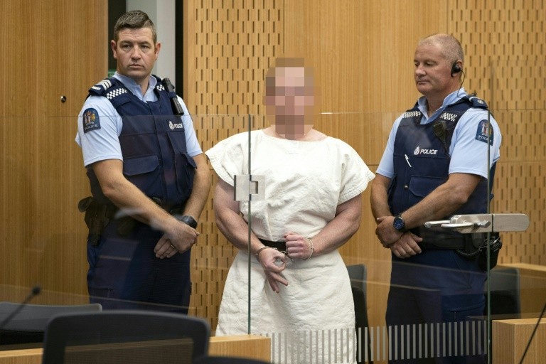 Brenton Tarrant, the accused Christchurch shooter, makes a white power sign during his court appearance 