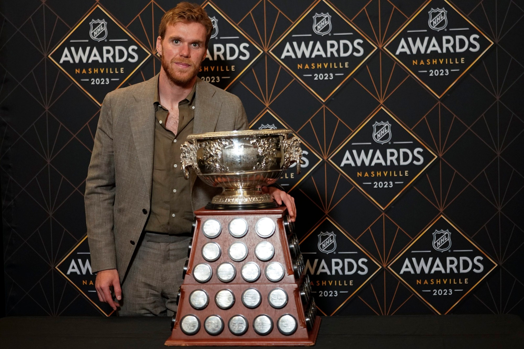 Hokejista Edmontonu Oilers Connor McDavid pózuje s Art Ross Trophy.
