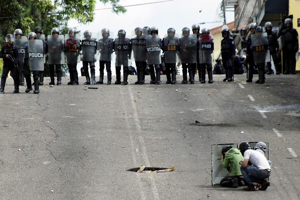 Riot security forces clash with demonstrators during a protest against Venezuelan President Maduro's