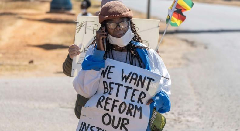 Zimbabwean novelist Tsitsi Dangarembga holds a placard during an anti-corruption march along Borrowdale road, in Harare; she was arrested and freed on bail the following day