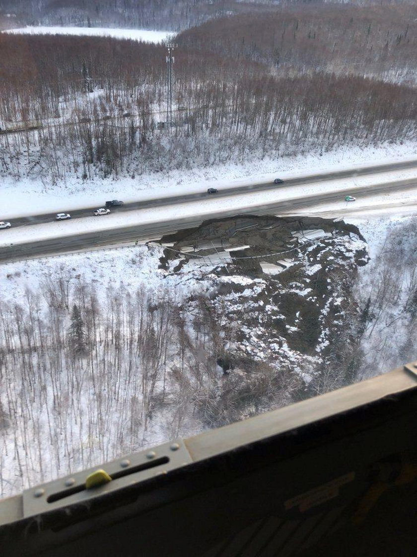 A vehicle lies stranded on a collapsed roadway near the airport after an earthquake in Anchorage